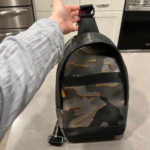 Coach one shoulder backpack, camo design in black, gray, and orange